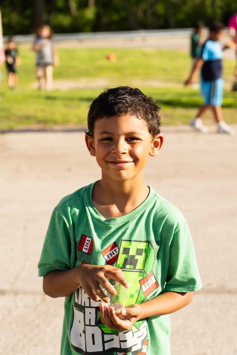 Child in green shirt at a community gathering